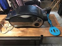 Easy Bake Oven and blue plastic spatula side by side on table