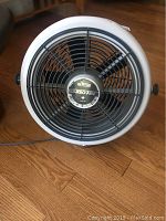 Front view of TurboAire Seabreeze fan displaying the black grille and central badge with model details.