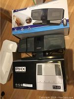 Photo showing unopened PHX Air Quality System with box and packaging, and the Garrison ceramic heater with its box.