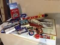 Overview of all items including plaque print, books, flags, stickers, patches, and plush toy