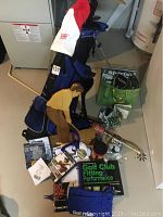 Full view of golf bag, clubs, stool, figurine, books, and various accessories on floor in basement.
