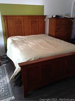 Assembled bed frame with mattress and dresser visible