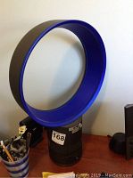 Fan assembled on wooden desk showing blue amplifier loop and gray base