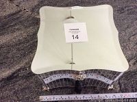 Top view showing the mirrored surface and curved edges with a measurement ruler for size reference.