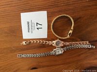 Top view of 4 ladies watches placed on a wooden surface
