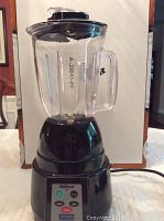 Front view of the blender showing glass pitcher with handle and lid and black base.