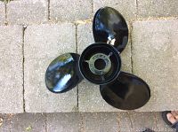 Top view of black 3-blade boat propeller showing the blades and hub.