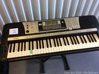 Front view of Yamaha PSR-740 showing keys with one key marked with green tape indicating possible malfunction.
