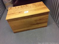 Rectangular maple wood chest closed, showing smooth wood grain and natural finish.