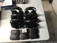 Six Sony MDR RF925R wireless headphones stacked together with six Sony SRF-18 transmitter units in front on a table.