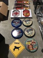 Various metal bottle cap wall decorations including motorcycle, automobile, vintage woman, and Ready for Duty designs alongside a yellow deer crossing traffic sign.