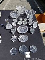 Full lot of assorted crystal dishes, vases, and decorative items arranged on a black cloth.