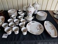 Full set of china laid out on black cloth showing all items included in the set.