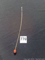 Full view of 30 inch gold-colored chain necklace with a gold-tone red teardrop pendant on a black background.