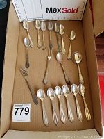 Full box view showing all silverware pieces included in the lot, laid out inside a cardboard box.