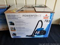 Box front and side showing Bissell PowerForce bagless canister vacuum with the model number 1665W and features.