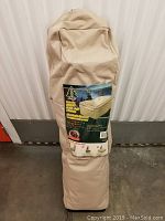 Closed beige carry bag holding the air bed and frame with printed label showing the bed image and product details.