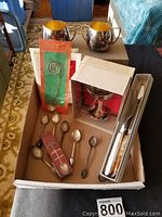 Variety of silver plate items including Nobility sugar dish and creamer, paper instructions, Viking wine glass in original box, collector spoons, and stainless steel carving set in cardboard box.