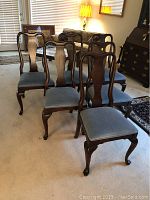 Group of six chairs from front-left angle showing shape, finish and upholstery