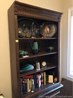 Front view of the Ethan Allen bookshelf filled with various decorative items and books.