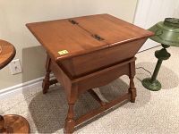 Angled side view of the solid maple wood vintage style table showing hinged compartment and turned legs.
