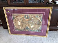 Full photo of the framed and matted world map leaning against cabinet on carpeted floor