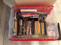 Top-down view showing full container with over 20 sports books including Maple Leafs and Blue Jays yearbooks.