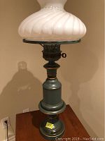 Toleware table lamp with milk glass shade, showing upper portion and swirling milk glass design
