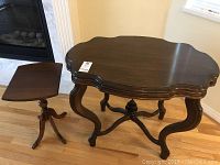 Full view of both the larger and smaller dark wood side tables showing shape, size, and design.