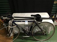 Front side view of the bike showing the full aluminum frame, camo patterned handlebar tape, and Profile brand rear racks.