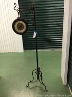 Full view of the 62 inch tall standing clock on decorative metal stand.