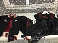 Harley Davidson black cloth jacket and black leather vest laid out showing front and details