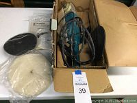 Makita electronic sander polisher in a box with power cord, polishing pads in plastic, and instruction manuals.