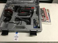Full view of the Rotozip Revolution tool and accessory storage case, showing the tool, blades, discs, and manuals.