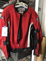 Full front view of the Joe Rocket red, black, and white mesh motorcycle jacket hanging on a white hanger.