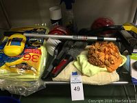 Car detailing supplies on a shelf including cloths, brushes, a squeegee, spray wax, cleaning pads, and sponges.