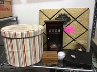 Assorted decor items including fabric hat box, shadow box cabinet, bulletin board, wood games, baseball and small wooden box.