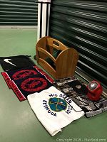 Overview of all items in the lot including towels, wooden holder, plant stand, and fan