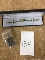 Watch and extra pieces displayed in presentation box with lot number card