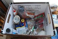 Box with various plumbing parts including valves, fittings, and adhesive.