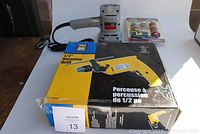 Box of 1/2 inch hammer drill and visible yellow hammer drill with cord.