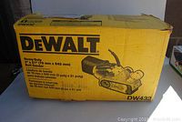 Original yellow DeWalt box with model DW432 label and printed illustration of the belt sander