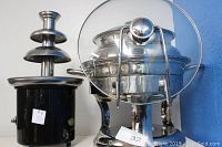 Chocolate tower fountain and large soup tureen side by side showing overall shape and size