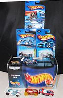 Photo showing a large Kyle Petty NASCAR Hot Wheels car in closed box along with three smaller loose Hot Wheels cars and three smaller Hot Wheels cars in their original blue packaging.