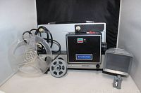 Photo of the Berkey Keystone 1550 dual 8mm movie projector with zoom lens, including film reels and a detachable projector lamp housing.