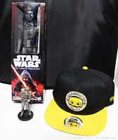 View of the 12-inch Kylo Ren figure in box, the 4-inch figure, and the C3PO snapback hat showing front patch and brim