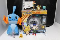 Full view of lot showing Mudkip plush, Tomy boxed set, and PVC figures arranged in front.