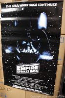 Full view of the black poster featuring Darth Vader and movie title with starry background.