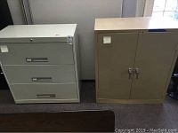 Photo of a 3-drawer lateral file cabinet and a beige two-door storage cabinet side by side under a window.
