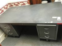 Full view of steel desk showing top surface and drawer areas on left and right sides